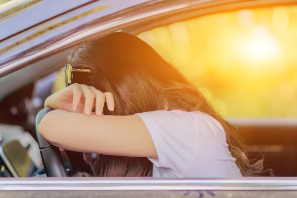 a young woman is driving a car to prepare for the driver's license examination