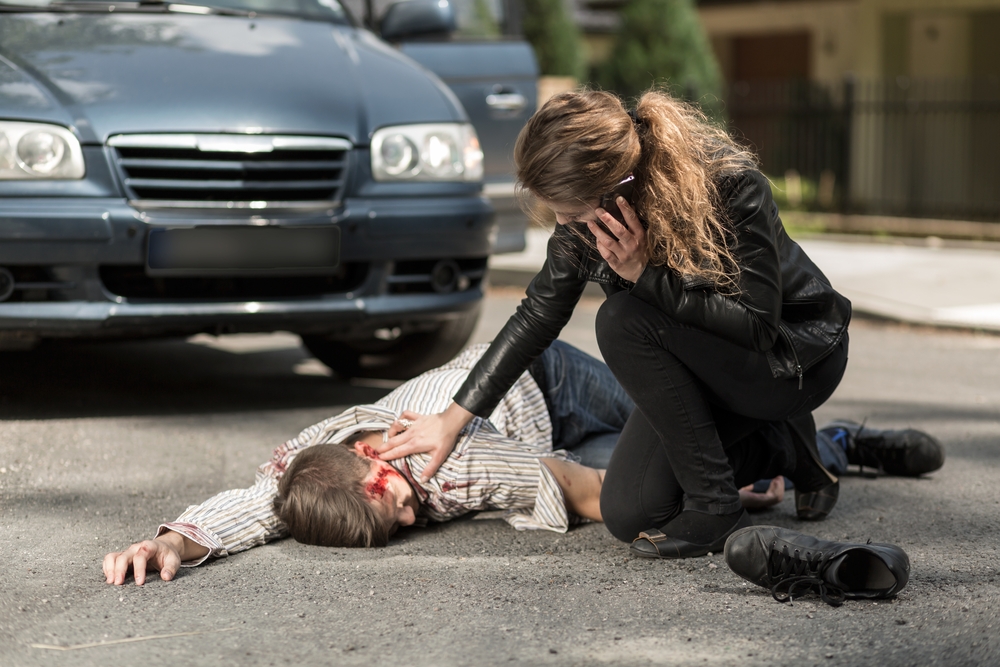 image of woman calling ambulance for injured man