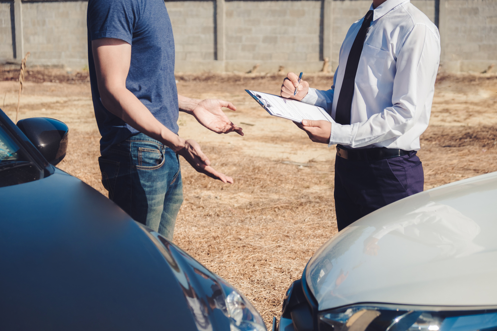 Insurance agent discussing with car owner for accident claim and processed