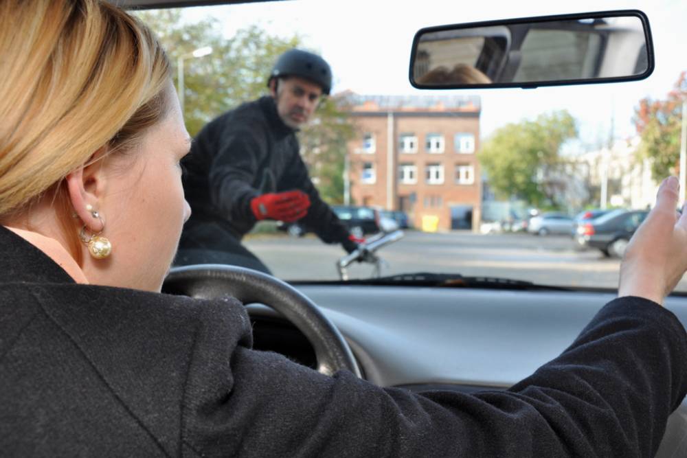 Car driver brings cyclists in dangerous situation in road traffic
