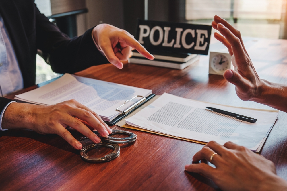Law enforcement officer interrogating Criminals male with handcuffs in the investigation room Police officer interviewing after committed a crime