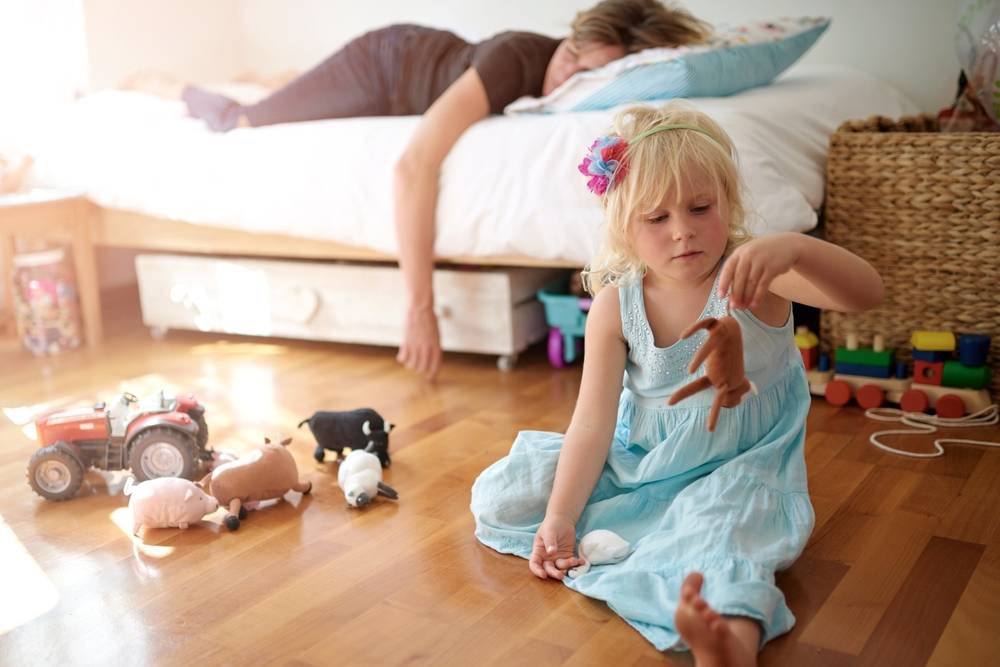 Sleeping mother, child and playing in house with toys, fatigue or burnout with kid neglect