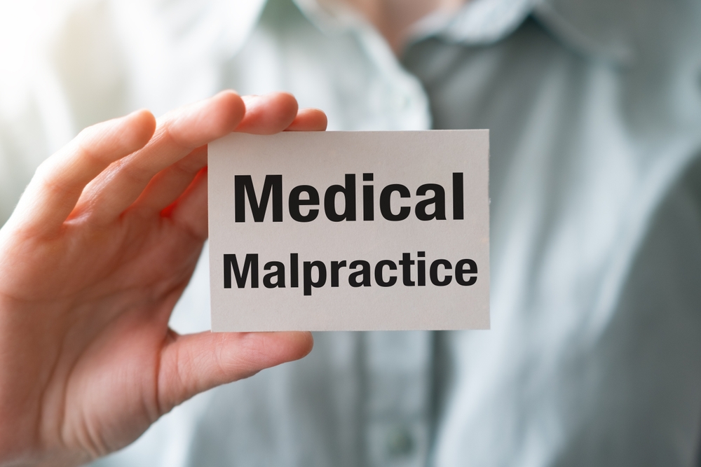Doctor holding a card with text Medical Malpractice