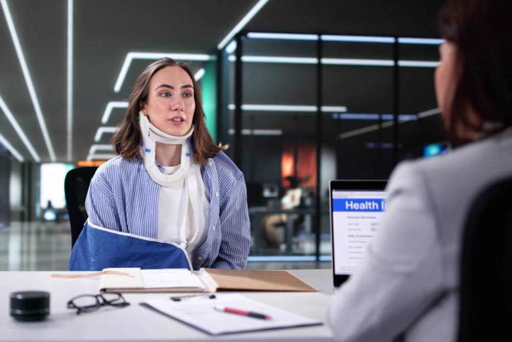 Woman filing worker injury compensation claim with insurance lawyer in accident.