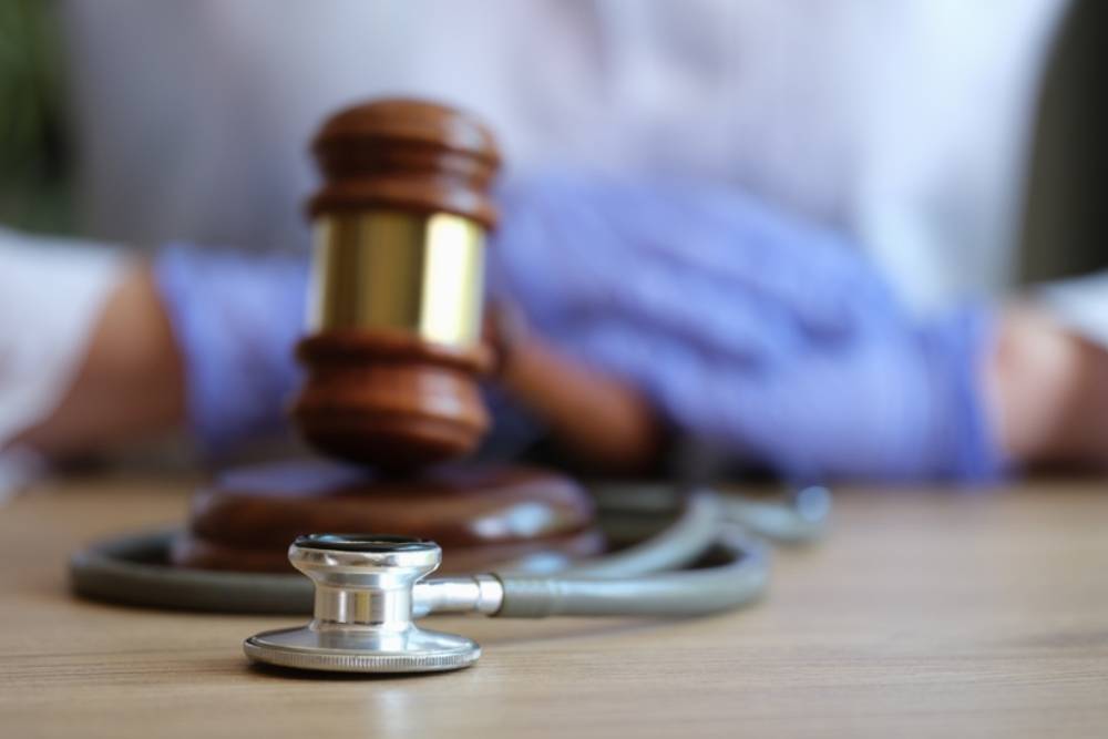 judge gavel, doctor stethoscope and woman doctor on background. Medical malpractice
