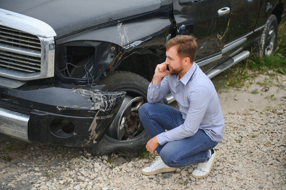 Man calling help after a car crash accident on the road.
