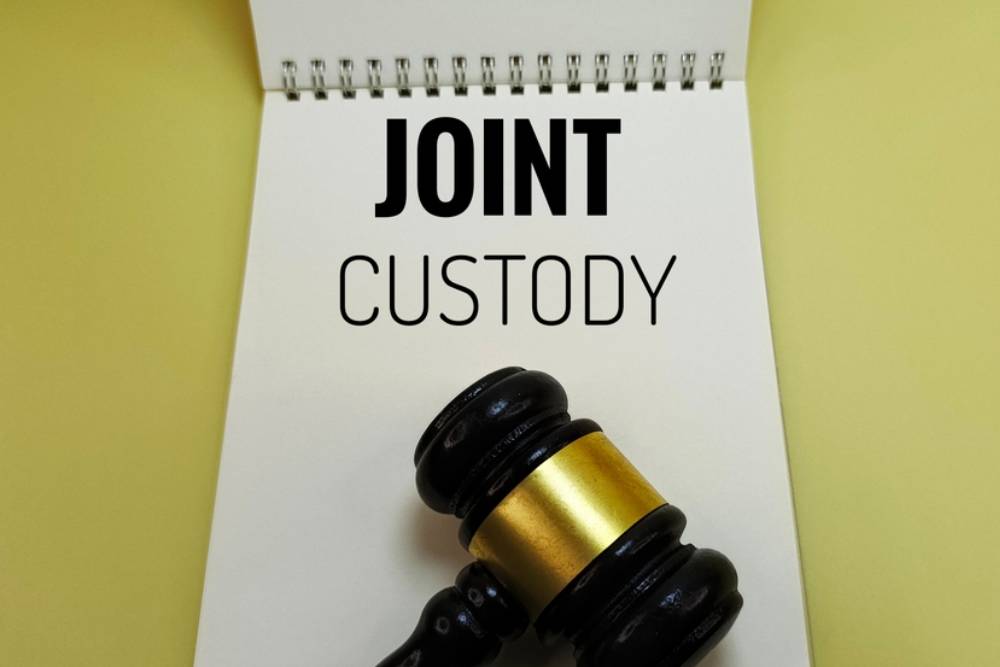 Joint Custody Agreement on Notebook with Judge Gavel Representing Shared Parenting